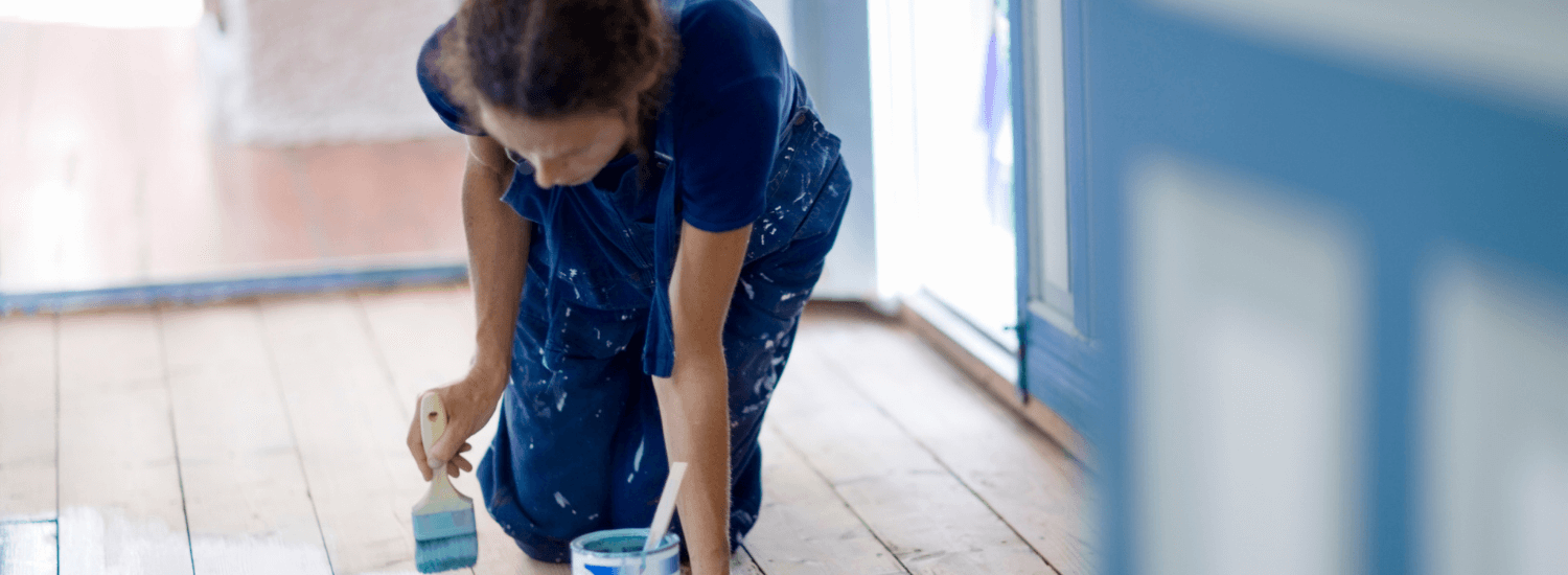 Woman painting wooden floor